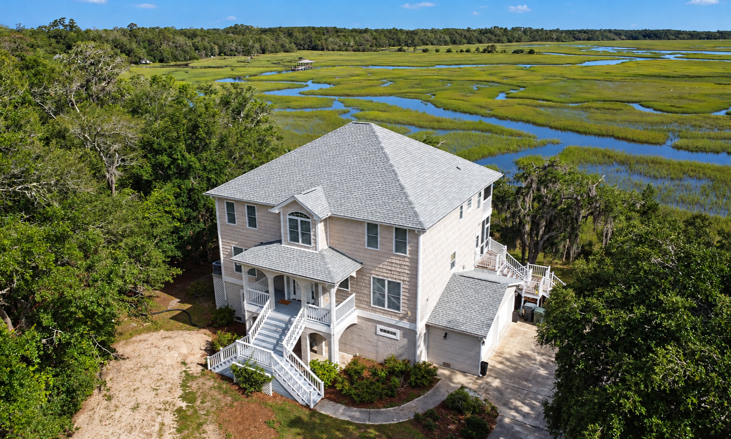 Coastal Georgia home in Brunswick with a light-colored shingle roof overlooking the marsh, photographed from above.